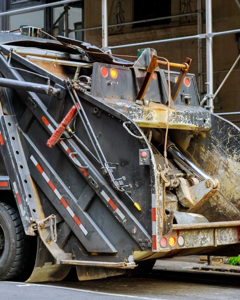 Buitinių atliekų surinkimo sunkvežimis ištuština konteinerį